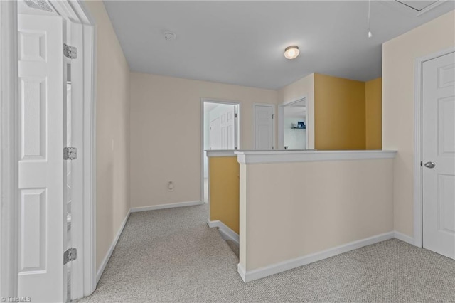 hallway with baseboards, attic access, carpet, and visible vents
