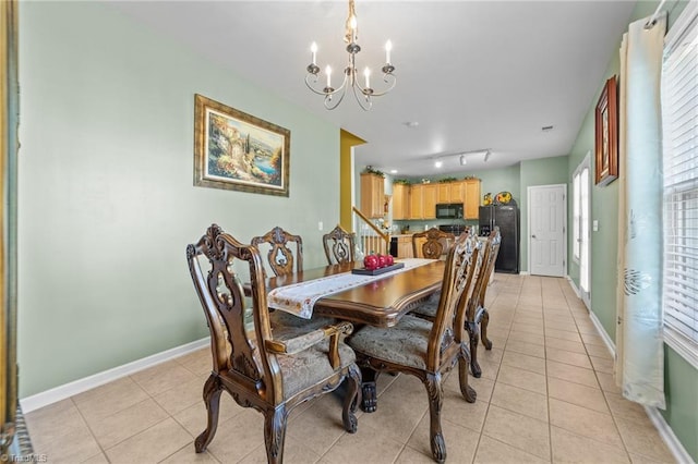 dining area featuring light tile patterned floors, baseboards, track lighting, and a chandelier