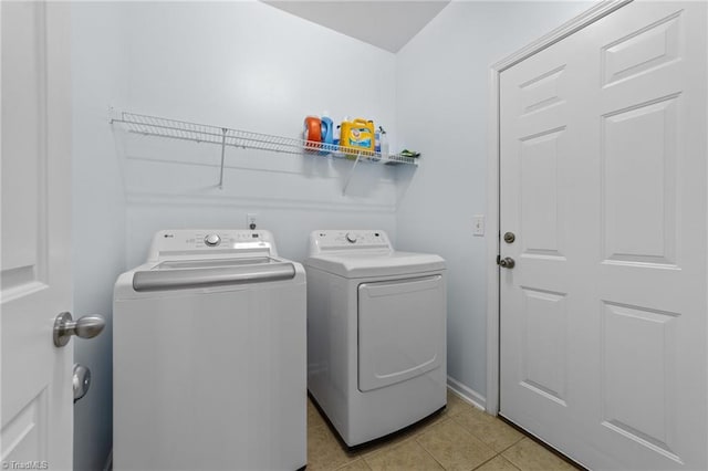 clothes washing area with laundry area, light tile patterned floors, and washing machine and clothes dryer