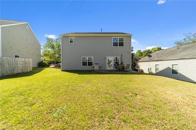 rear view of house with a patio area, fence, and a yard