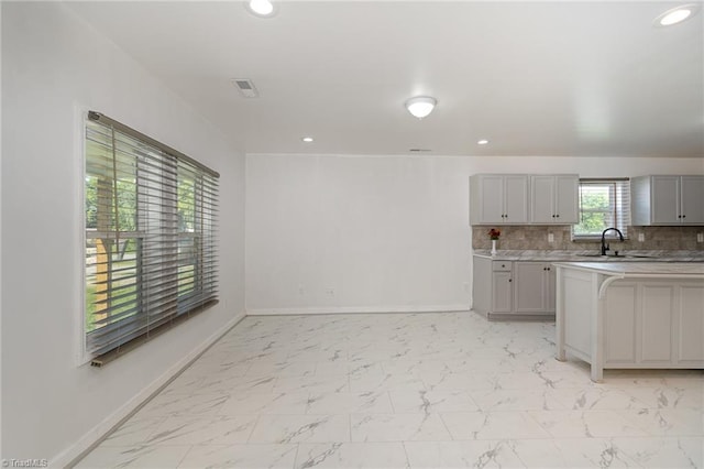 304 Ingram St, Thomasville, NC 27360 - kitchen with gray cabinets, recessed lighting, light countertops, backsplash, and light marble finish flooring