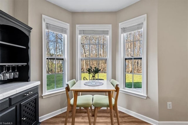 dining area with baseboards and wood finished floors