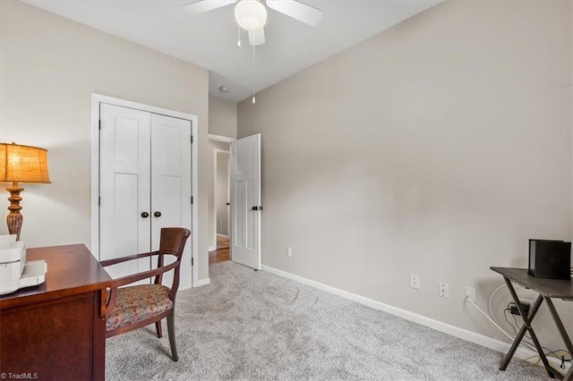 carpeted office space with baseboards and ceiling fan