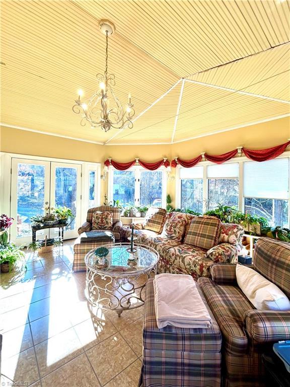 sunroom / solarium with a chandelier, french doors, and plenty of natural light