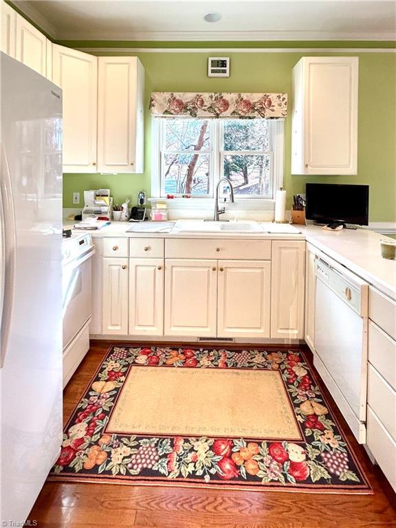 kitchen featuring white cabinets, white appliances, and sink