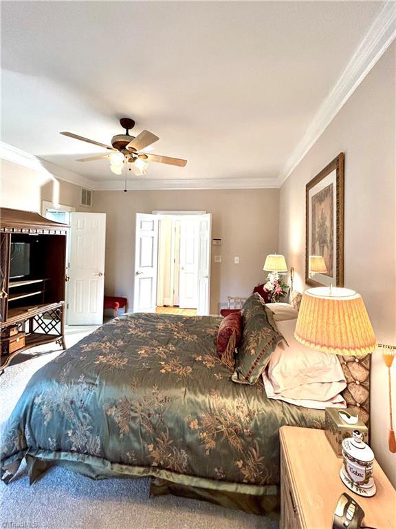 bedroom with ceiling fan and crown molding