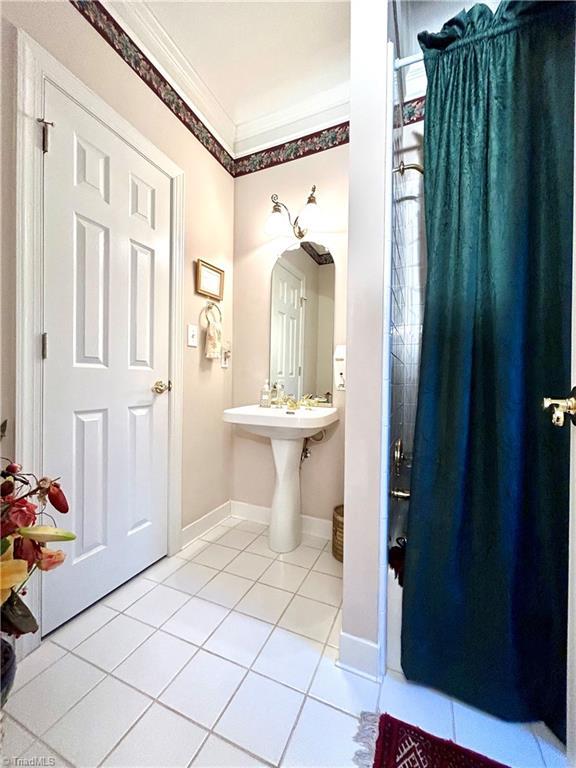 bathroom featuring tile patterned flooring and crown molding