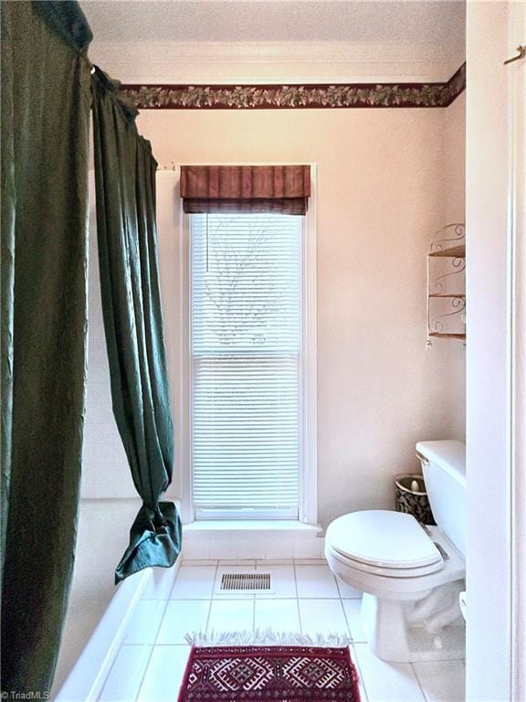 bathroom featuring tile patterned flooring, ornamental molding, a textured ceiling, and toilet