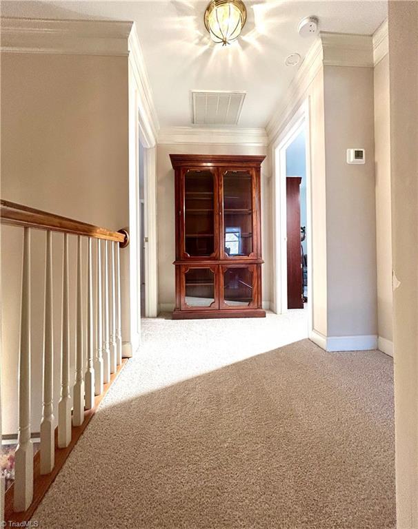 corridor with carpet and ornamental molding