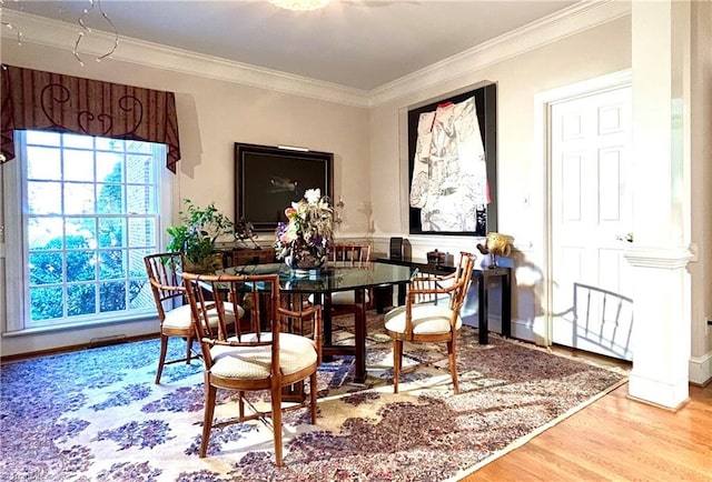 dining room with crown molding and light hardwood / wood-style flooring