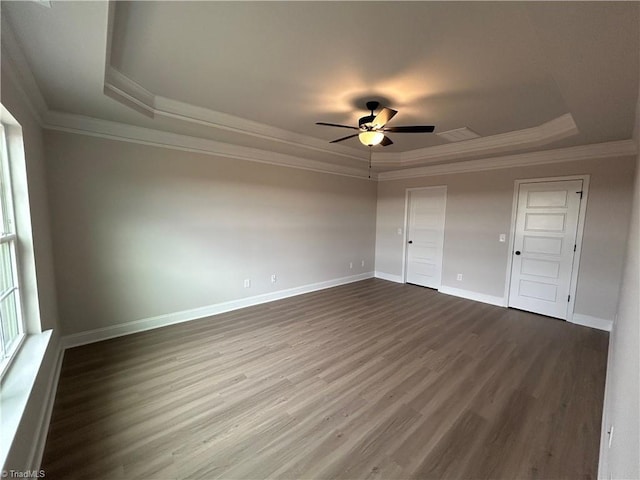 unfurnished bedroom featuring a raised ceiling, ornamental molding, and dark hardwood / wood-style floors