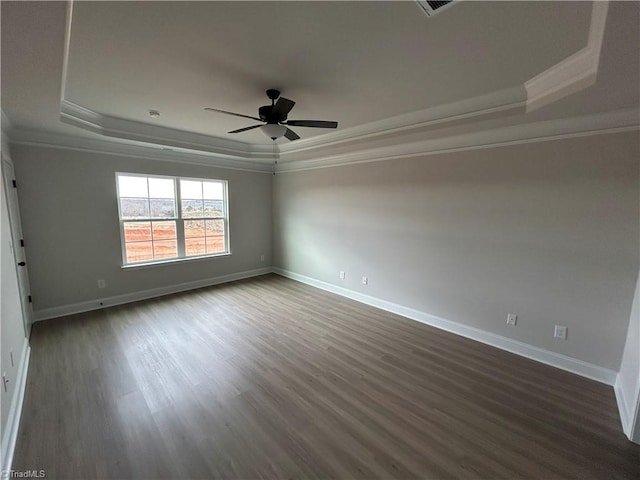 unfurnished room with a raised ceiling, crown molding, dark wood-type flooring, and ceiling fan