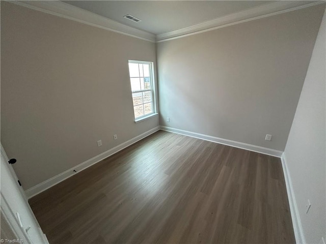 empty room with ornamental molding and dark hardwood / wood-style flooring