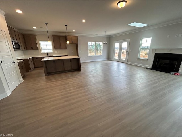 unfurnished living room with ornamental molding, sink, dark hardwood / wood-style floors, and a healthy amount of sunlight