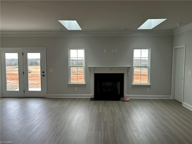 unfurnished living room featuring hardwood / wood-style floors, crown molding, and a wealth of natural light