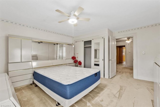bedroom featuring baseboards, ceiling fan, a closet, and light colored carpet