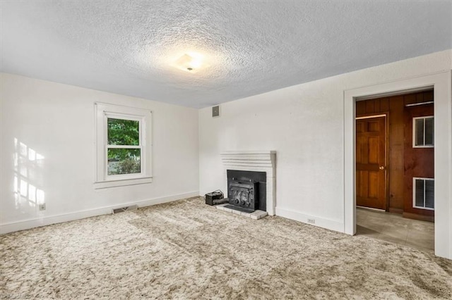 unfurnished living room featuring carpet floors, baseboards, a textured ceiling, and visible vents