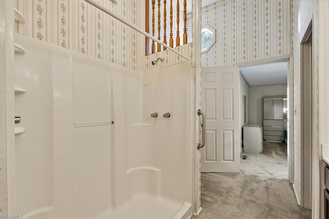bathroom featuring a shower stall and wallpapered walls