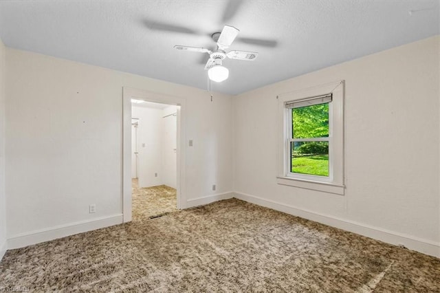 spare room with carpet floors, a textured ceiling, baseboards, and ceiling fan
