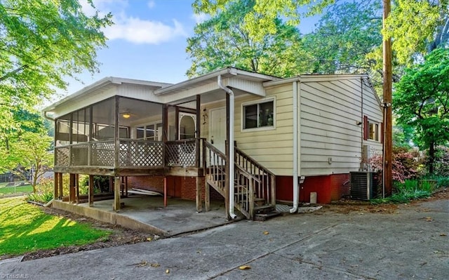 exterior space with central air condition unit and a sunroom