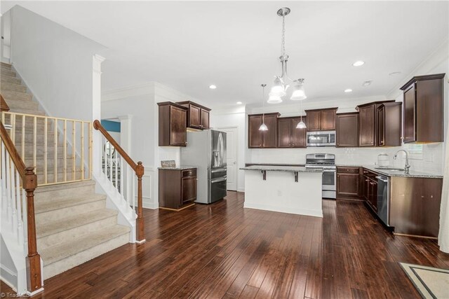 301 Summerwalk Rd, Greensboro, NC 27455 - kitchen with appliances with stainless steel finishes, crown molding, a kitchen island, dark wood-style floors, and dark brown cabinetry
