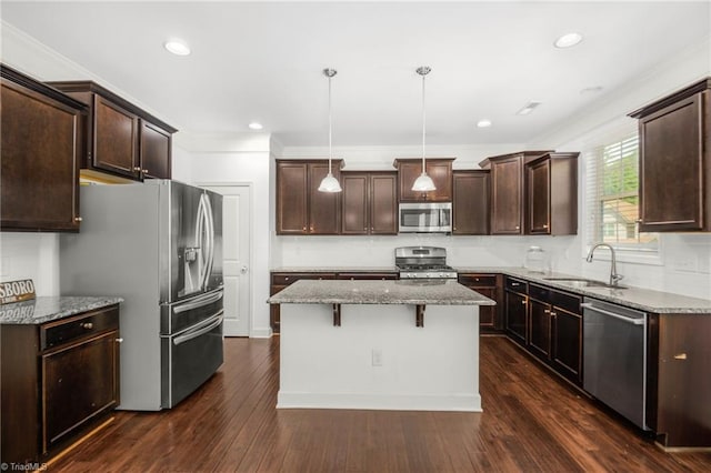 301 Summerwalk Rd, Greensboro, NC 27455 - kitchen featuring appliances with stainless steel finishes, dark brown cabinetry, a kitchen island, light stone counters, and a breakfast bar