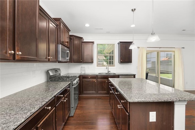 301 Summerwalk Rd, Greensboro, NC 27455 - kitchen featuring appliances with stainless steel finishes, dark wood finished floors, a kitchen island, ornamental molding, and light stone counters