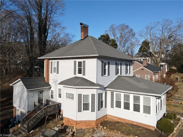 back of property featuring a wooden deck and a storage shed