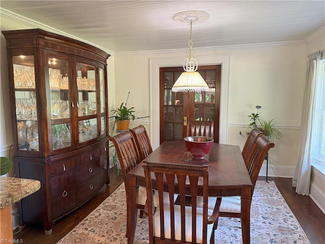 dining room with dark wood-style floors, crown molding, and baseboards