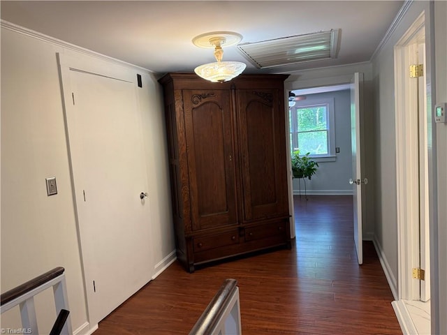 corridor with dark wood finished floors, baseboards, and crown molding