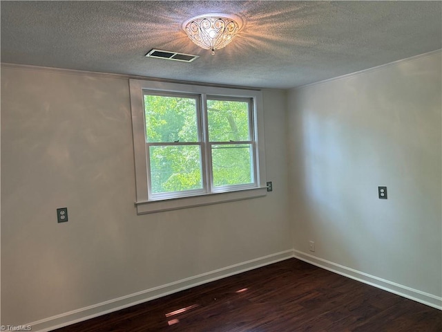 unfurnished room featuring a textured ceiling, dark wood-type flooring, baseboards, and ornamental molding