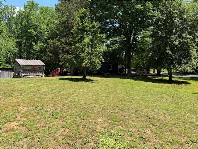 view of grassy yard with a shed and an outbuilding