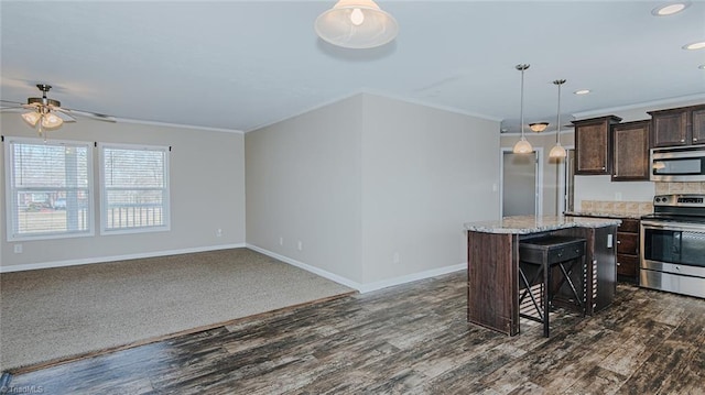 kitchen with a kitchen island, a kitchen bar, dark brown cabinetry, stainless steel appliances, and crown molding