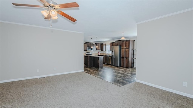 unfurnished living room featuring ceiling fan, ornamental molding, and dark carpet