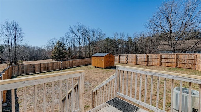 wooden terrace featuring central AC unit and a storage shed