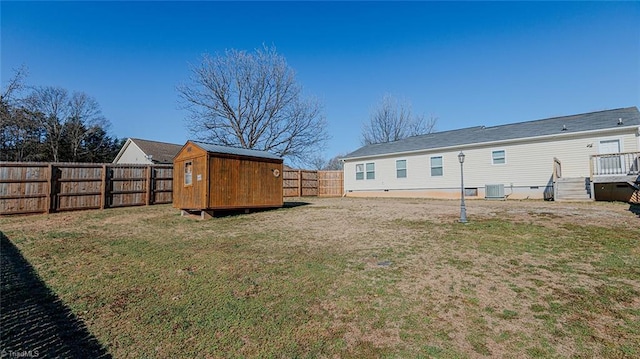 exterior space featuring a yard, central AC, and a storage unit