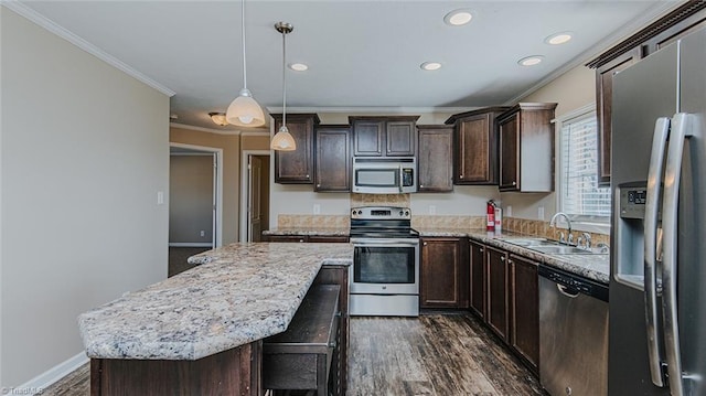 kitchen featuring decorative light fixtures, sink, a center island, stainless steel appliances, and crown molding