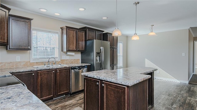 kitchen featuring dark brown cabinetry, hanging light fixtures, sink, and appliances with stainless steel finishes