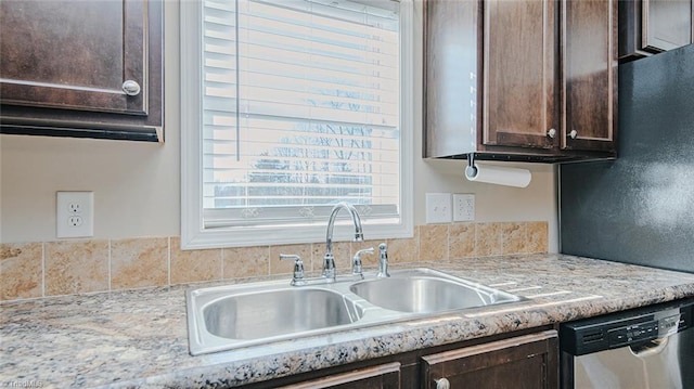 kitchen featuring dark brown cabinetry, sink, light stone counters, and stainless steel dishwasher