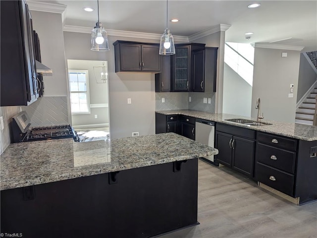 kitchen with kitchen peninsula, a kitchen breakfast bar, hanging light fixtures, range, and stainless steel dishwasher