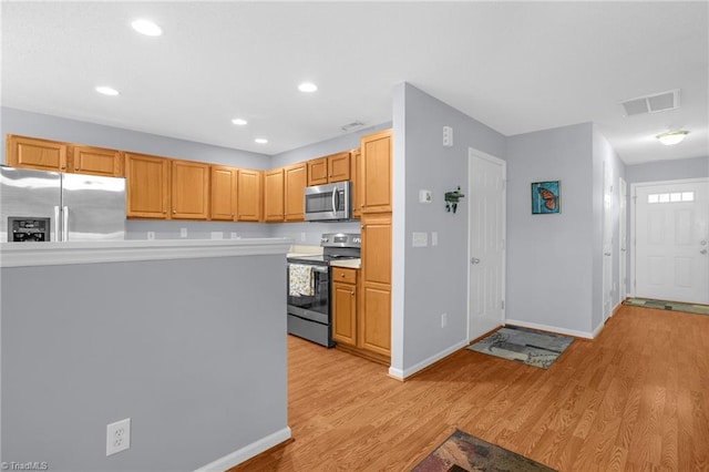 kitchen with light wood-type flooring, stainless steel appliances, and light brown cabinetry