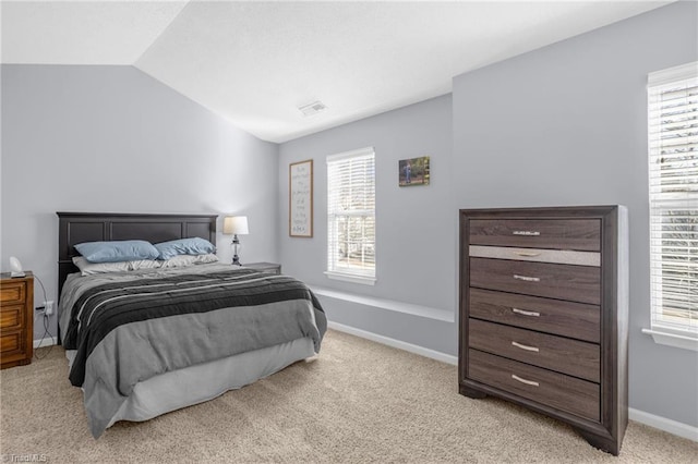 bedroom with light colored carpet and multiple windows