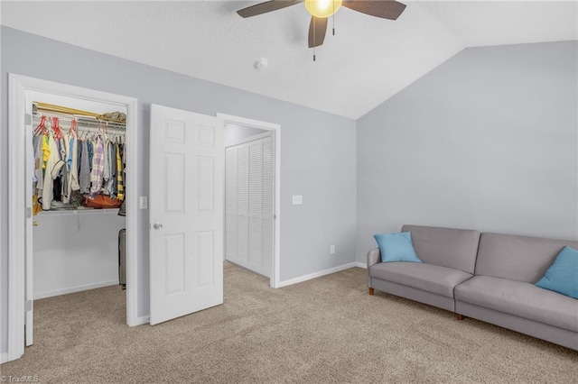 living room with ceiling fan, light colored carpet, and vaulted ceiling