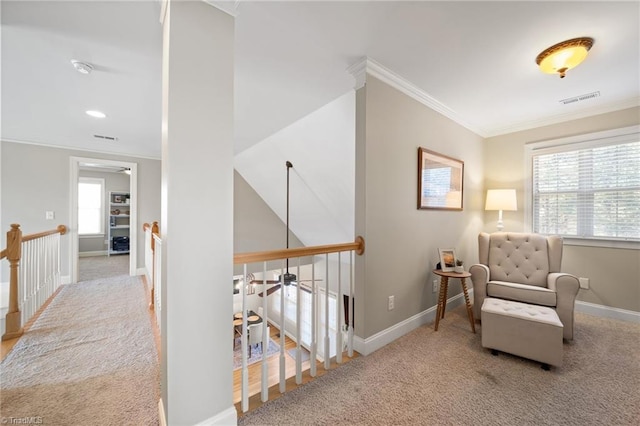 sitting room featuring visible vents, an upstairs landing, carpet, crown molding, and baseboards