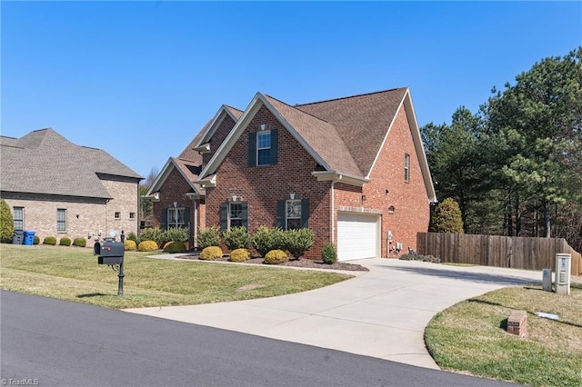 view of front of property with brick siding, a front lawn, fence, a garage, and driveway