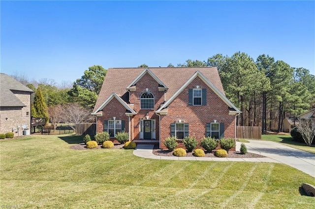 view of front of property featuring brick siding, a front yard, and fence