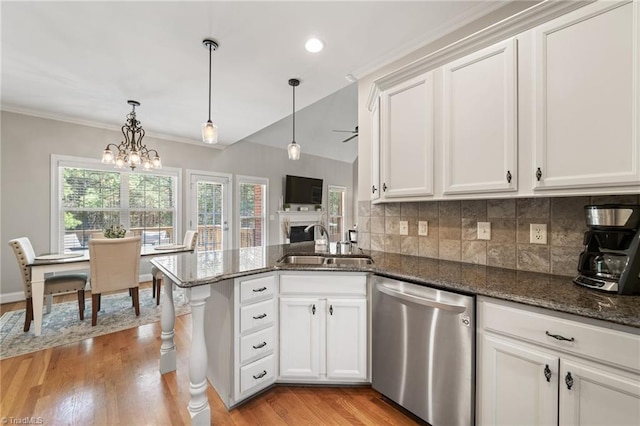 kitchen with a sink, tasteful backsplash, stainless steel dishwasher, a peninsula, and white cabinets