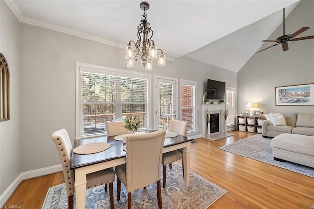 dining room with a high end fireplace, crown molding, baseboards, and light wood finished floors