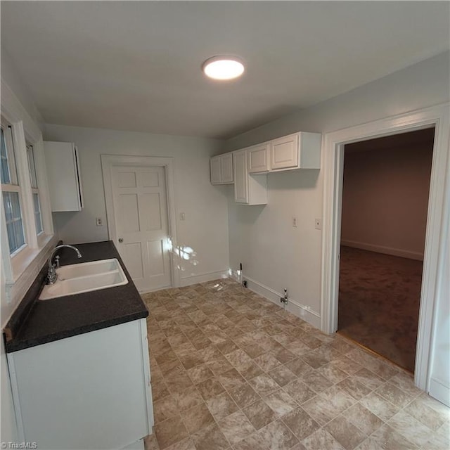 kitchen featuring white cabinetry and sink