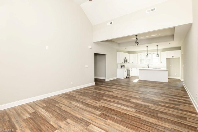 112 Emerald Ct, Trinity, NC 27370 - unfurnished living room featuring baseboards, dark wood-style flooring, a sink, and high vaulted ceiling